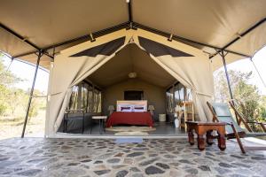 a large tent with a bed in it at Entalet Mara Camp in Talek