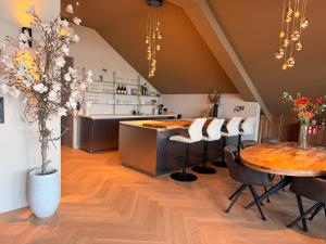 a kitchen with a table and chairs and a counter at Enjoy Heaven in Schellinkhout