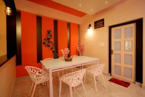 a dining room with a white table and chairs at Skylark Home in Mananthavady