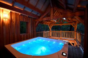 a large hot tub on the deck of a cabin at Les 7 Montagnes in Lourdes