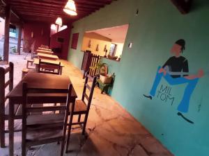 a dining room with a mural on the wall at Bituca Hostel e Café in Milho Verde
