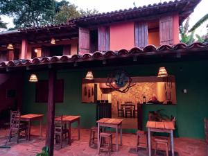 a restaurant with tables and chairs in front of a building at Bituca Hostel e Café in Milho Verde +10 photos