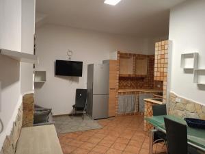 a kitchen with a refrigerator and a tv on the wall at Fabian Appartament in Bagheria