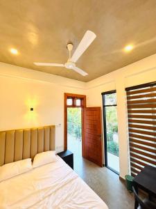 a bedroom with a bed and a ceiling fan at Ceylan Dream Hiriketiya in Nilwella