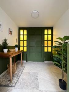 a green door in a room with a potted plant at Peonía Tempo in Esquel