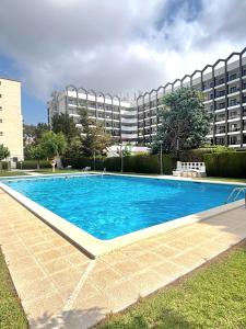 a swimming pool in front of a large building at Salou Guesthouse in Salou