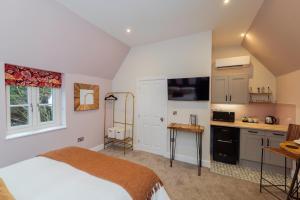 a bedroom with a bed and a small kitchen at The Station at Shustoke - Birmingham Airport & NEC in Shustoke