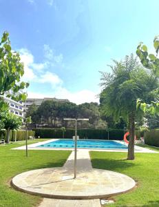 a swimming pool in a park with a tree at Salou Guesthouse in Salou