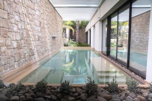 ein Infinity-Pool in einem Haus mit einer Steinmauer in der Unterkunft Sunset Hotel in Cefalú
