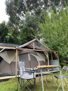 a tent with chairs and a table in front of it at Glamping Mañihueico in Contao