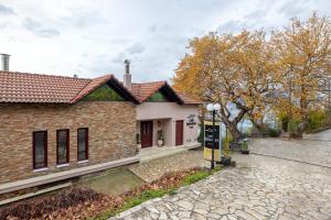 a brick house with a sign in front of it at Lake Kremasta Hotel in Neokhórion