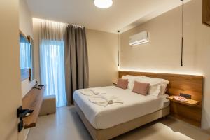 a hotel room with a bed with towels on it at Mystrali 2BD Modern Apt with Private Garden in Galatás