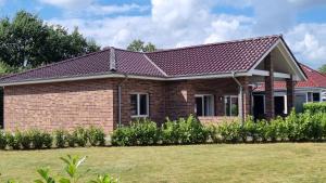 a brick house with a red roof at STRANDhaus Viktoria in Walchum