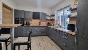 a kitchen with grey cabinets and a table and chairs at STRANDhaus Viktoria in Walchum
