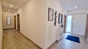 a hallway with white walls and a blue rug at STRANDhaus Viktoria in Walchum