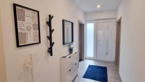 a hallway with white walls and a blue rug at STRANDhaus Viktoria in Walchum