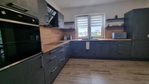 a large kitchen with blue cabinets and a window at STRANDhaus Viktoria in Walchum +20 photos