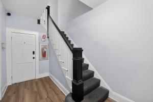 a staircase in a house with a black stair case at Cozy Baltimore Studio apts in Baltimore +21 photos