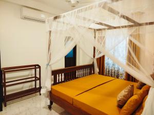 a bedroom with a canopy bed and a window at River Breeze Villa in Nikawatawana