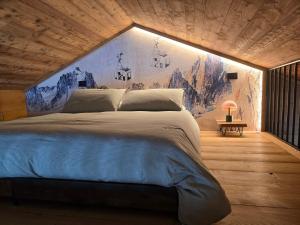 a bedroom with a large bed with a painting on the wall at Olterzuba Hus in Alagna Valsesia +72 photos