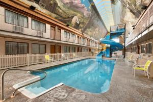 a large swimming pool with a slide in a building at Days Inn by Wyndham Lethbridge in Lethbridge