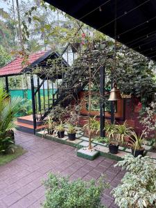 a garden with a spiral staircase and potted plants at Skylark Home in Mananthavady
