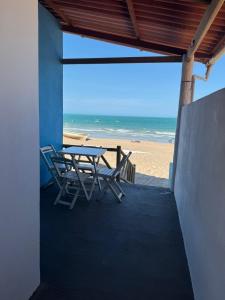 a table and chairs sitting on the beach at Chalé marlin azul in Icapuí