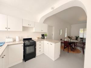 a kitchen with white cabinets and a black stove at Crescent House in Franschhoek