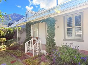 a white house with an ivy covered stairway at Crescent House in Franschhoek
