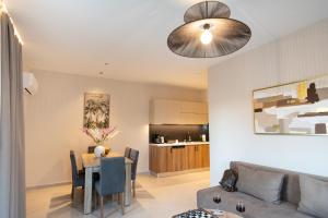 a living room with a table and a couch at Mystrali 2BD Modern Apt with Private Garden in Galatás