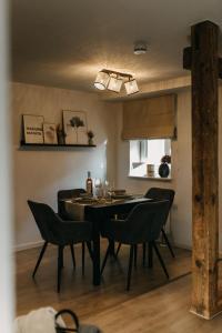 a dining room with a black table and chairs at Komfortables Apartment nahe Weimar in Umpferstedt