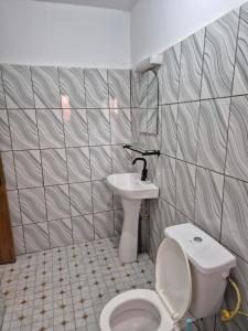 a bathroom with a toilet and a sink at G and E Guesthouse in Kumba +12 photos