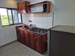 a kitchen with a stove and a refrigerator at G and E Guesthouse in Kumba