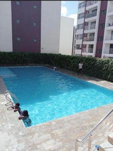a person is playing in a large blue swimming pool at Serene Cozy Studio behind Signature Mall in Marimbeti
