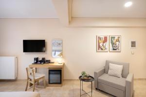 a living room with a couch and a chair and a desk at Lake Kremasta Hotel in Neokhórion
