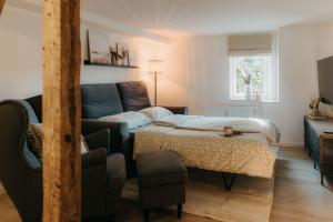 a living room with a couch and a bed at Komfortables Apartment nahe Weimar in Umpferstedt