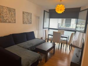 a living room with a couch and a table at Relájate en Ramales de la Victoria, apartamento con piscina y parking in Ramales de la Victoria