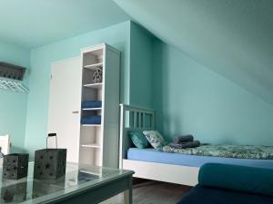 a blue room with a bed and a glass table at Ferienhaus Rennsteiggruss in Lauscha