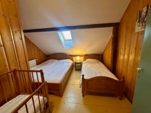 a small room with two beds and a skylight at Chata Hnyk in Zlatá Olešnice