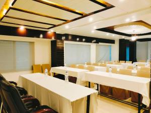 a conference room with white tables and chairs at Hotel The Al Aqsa in Chittagong
