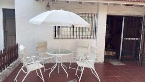 a table with chairs and an umbrella on a patio at Santa Cruz 5761 in Mar del Plata