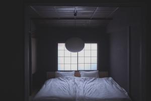 a bedroom with a large bed with a window at new tradition hotel kanazawa in Kanazawa