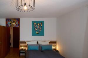 a bedroom with a bed and a chandelier at Asmus Unterkunft in Immenstadt im Allgäu