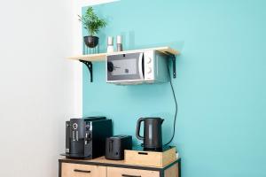 a shelf with a microwave on a blue wall at Asmus Unterkunft in Immenstadt im Allgäu