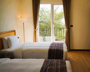 a hotel room with two beds and a window at 翡秝大飯店 in Beinan