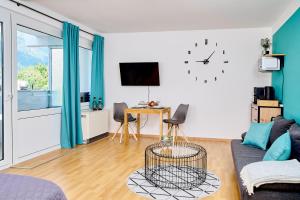 a living room with a couch and a clock on the wall at Asmus Unterkunft in Immenstadt im Allgäu