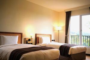 a hotel room with two beds and a window at 翡秝大飯店 in Beinan