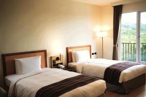 a hotel room with two beds and a balcony at 翡秝大飯店 in Beinan