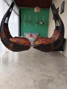 a room with two swing chairs and a bed at Tropical Crystal House in Guápiles