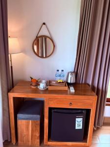 a room with a table with a tv and a mirror at Wana Ayu Jelijih Villas by Dhananjaya Hospitality in Tampaksiring